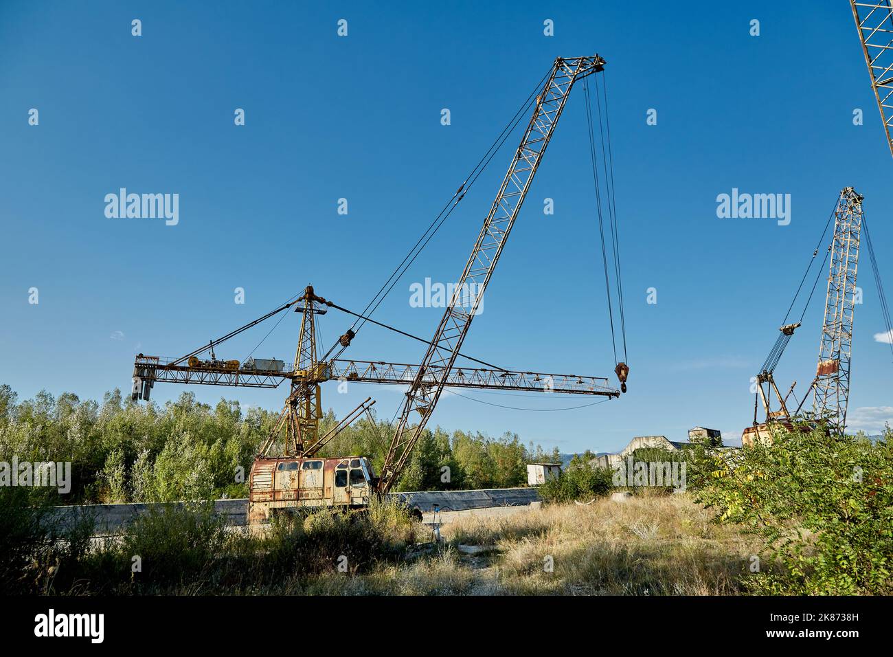 Rusty cranes in an abandoned hydrotechnical construction site. Stock Photo