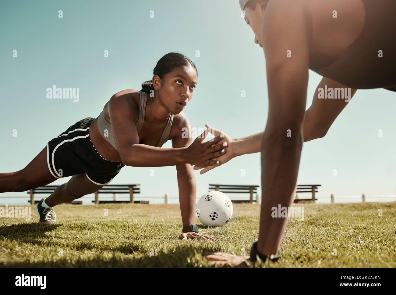 Fitness partner, exercise and sport training with couple workout in a park doing pushup for wellness in nature. Breathing, soccer ball and woman with Stock Photo