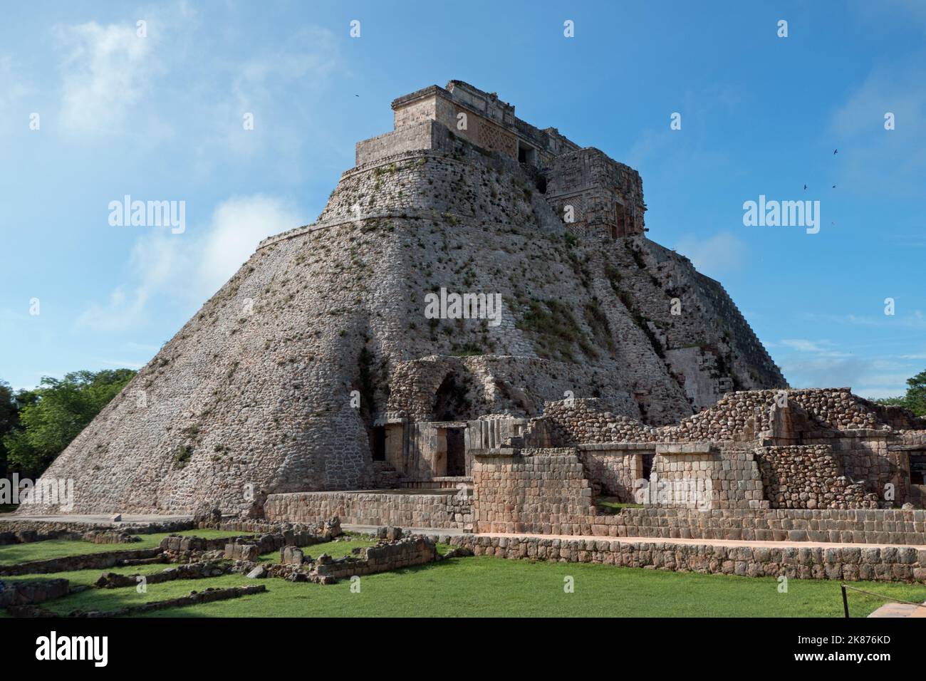 View of the Maya archeological site of Uxmal in Yucatan, Mexico. Mayan ruins with Pyramid Of The Magician and ancient building for tourism and travel Stock Photo