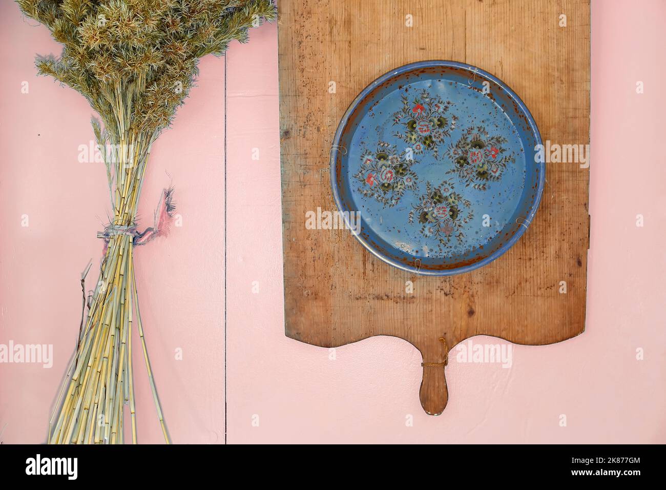 yellow kitchen objects and decor, wooden board and plate with decorative branches - blue top Stock Photo