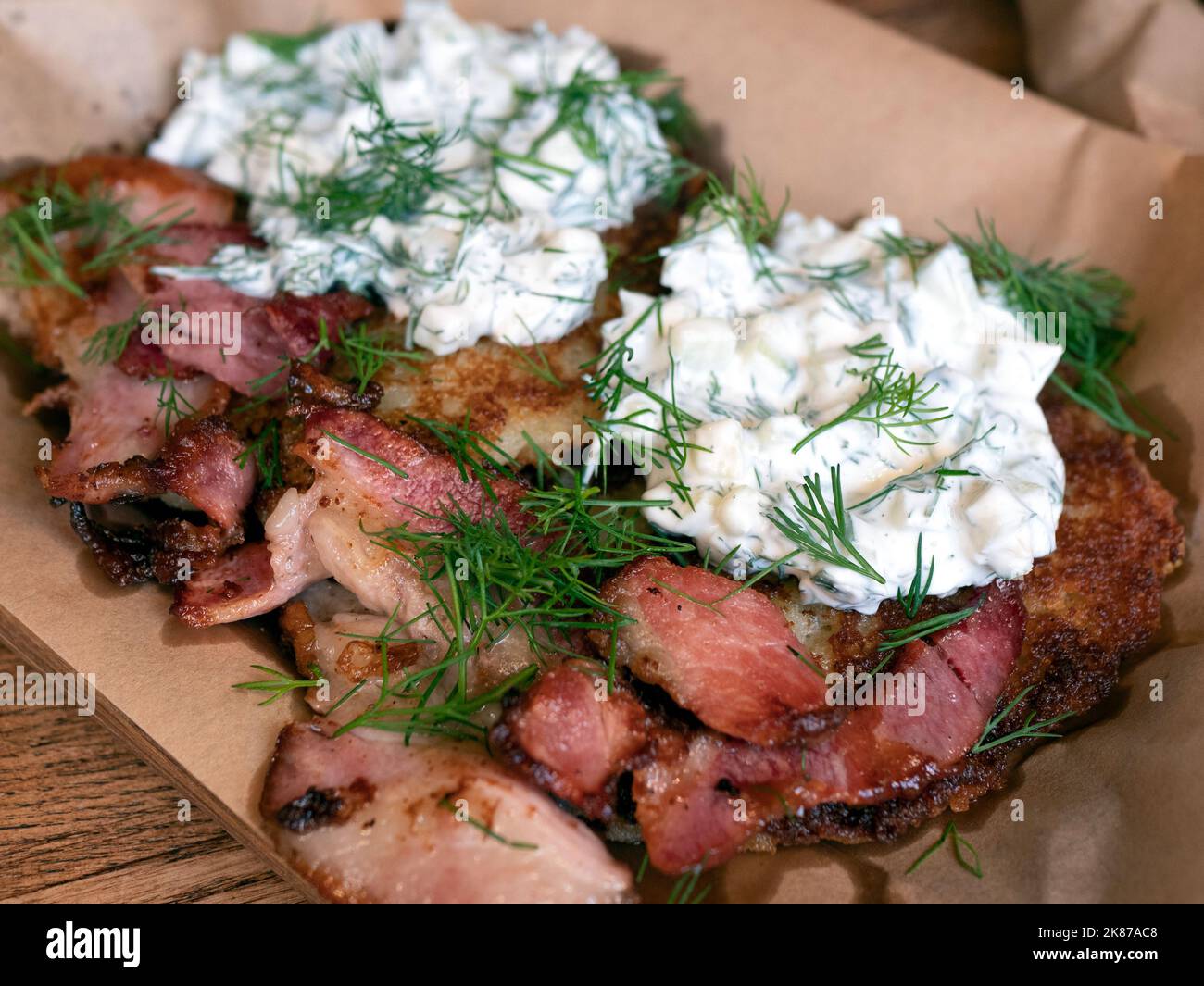 Crispy potato rosti stacked with fried bacon topped with a garlicky