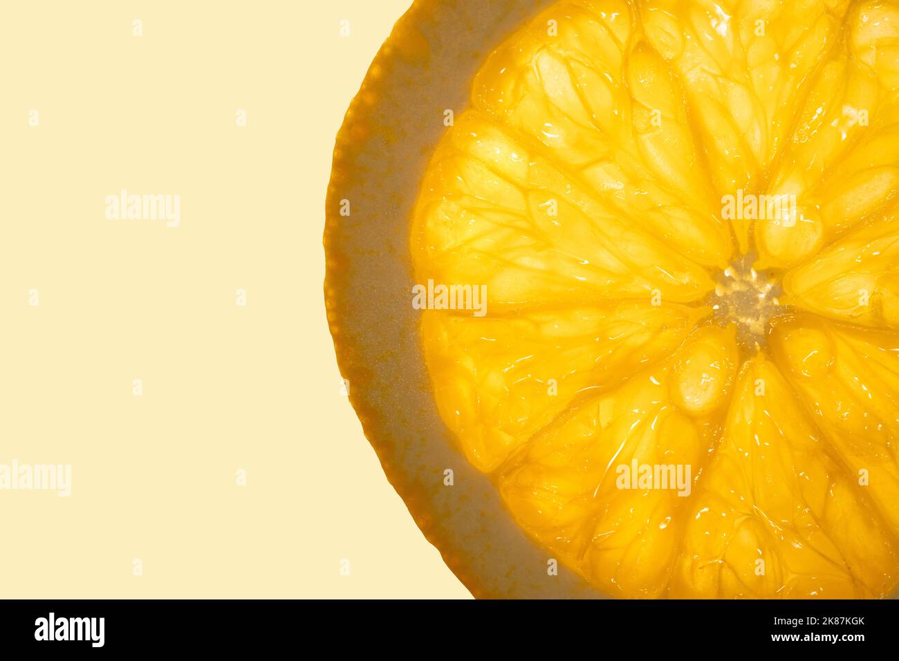 Slice of fresh juicy orange fruit close up on light orange copy space background. Macro photography concept.  Stock Photo