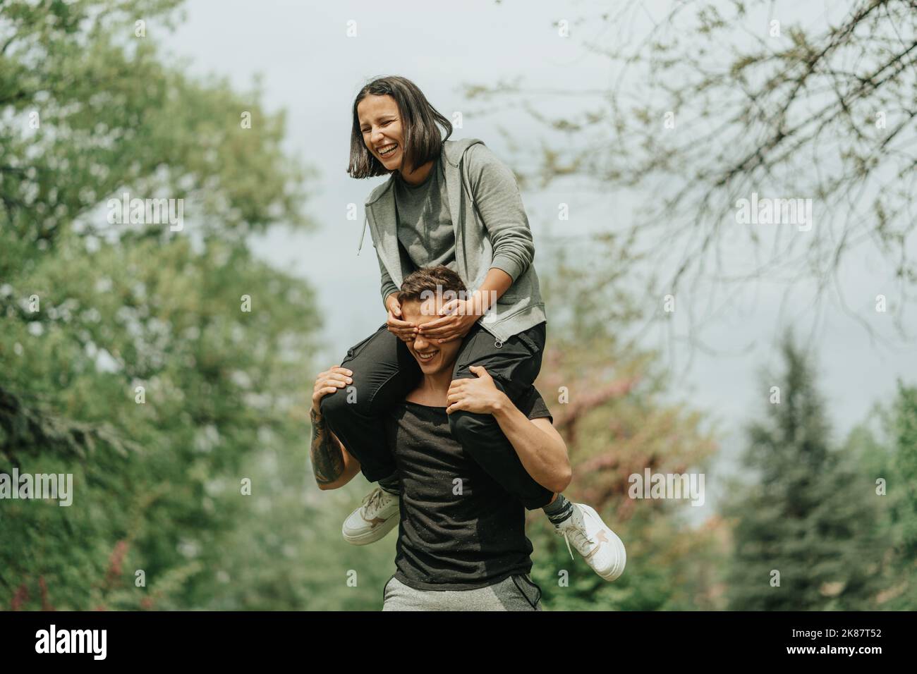 Beautiful gilr is playing peak a boo with her boyfriend in the park Stock Photo