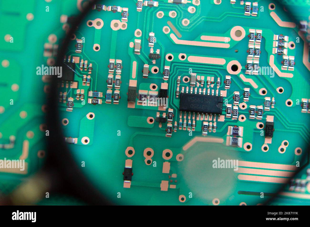 A magnifying glass showing an electronic circuit board in detail Stock ...