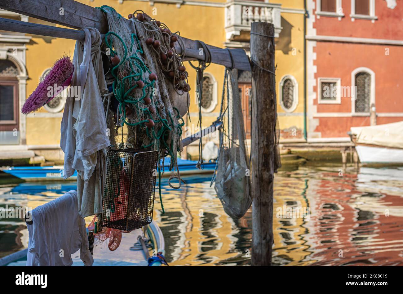 Colorful boats and fishing nets along the canal - Chioggia city, Venice Lagoon, Verona province, northern Italy Stock Photo