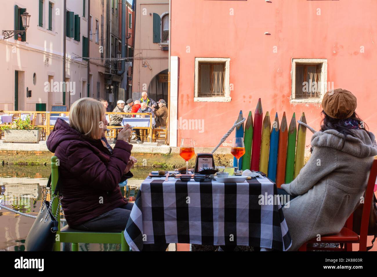 Tourists at the outdoor tables of restaurant Chioggia along the canal - Chioggia, Venetian lagoon, Veneto region,northern Italy Stock Photo