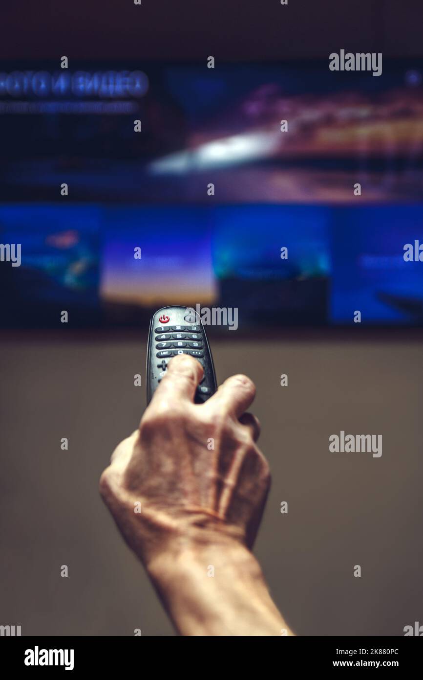 elderly man hand holding TV remote control. Stock Photo