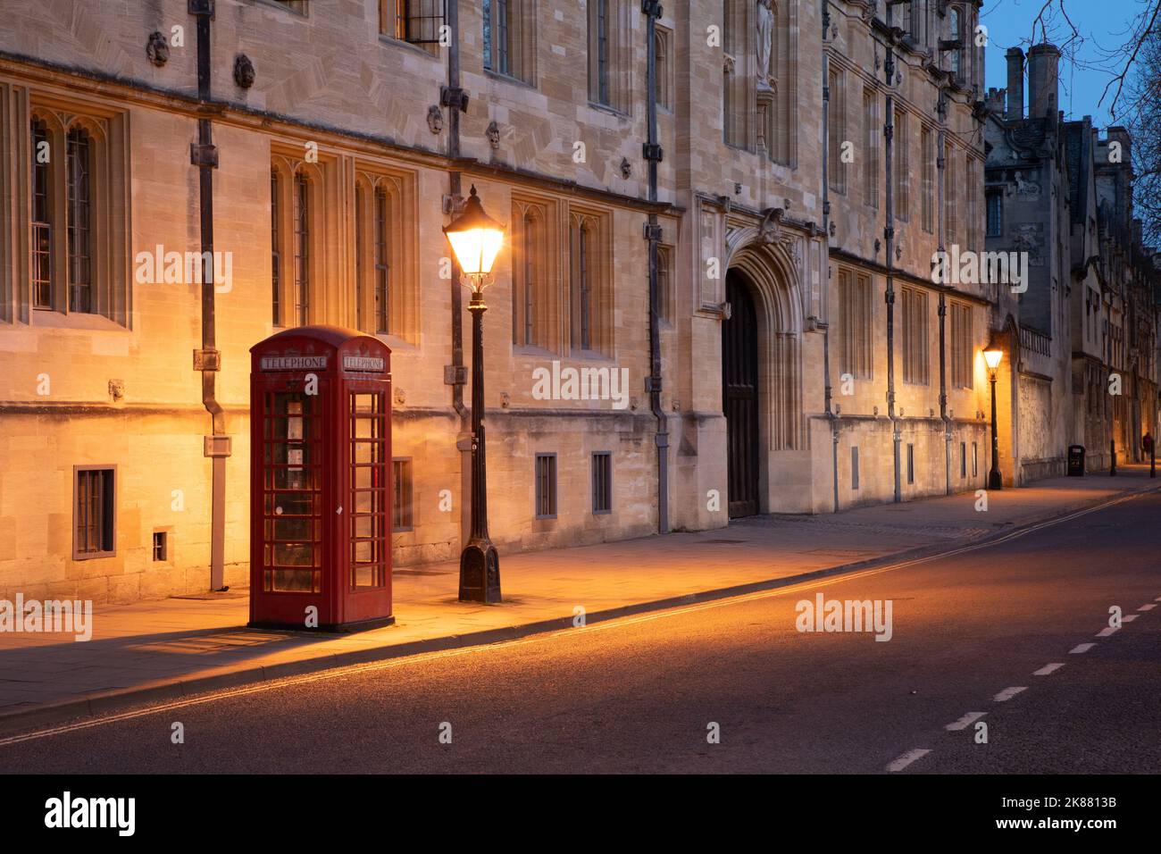lluminated iconic red British telephone box in Oxford city centre after dark during lockdown. Stock Photo