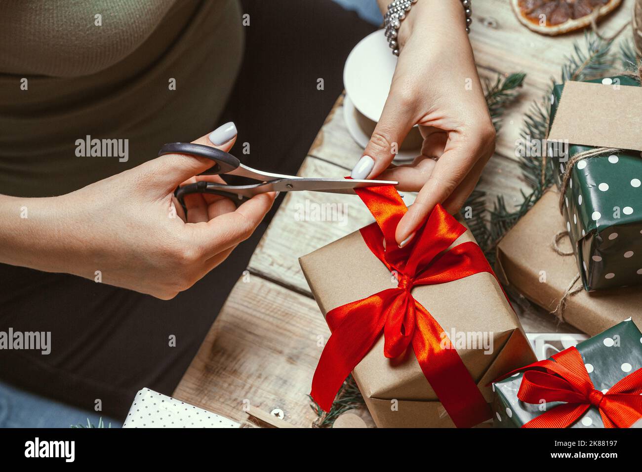 Young woman wrapping and decorates a lot of stack of gifts chri Stock Photo