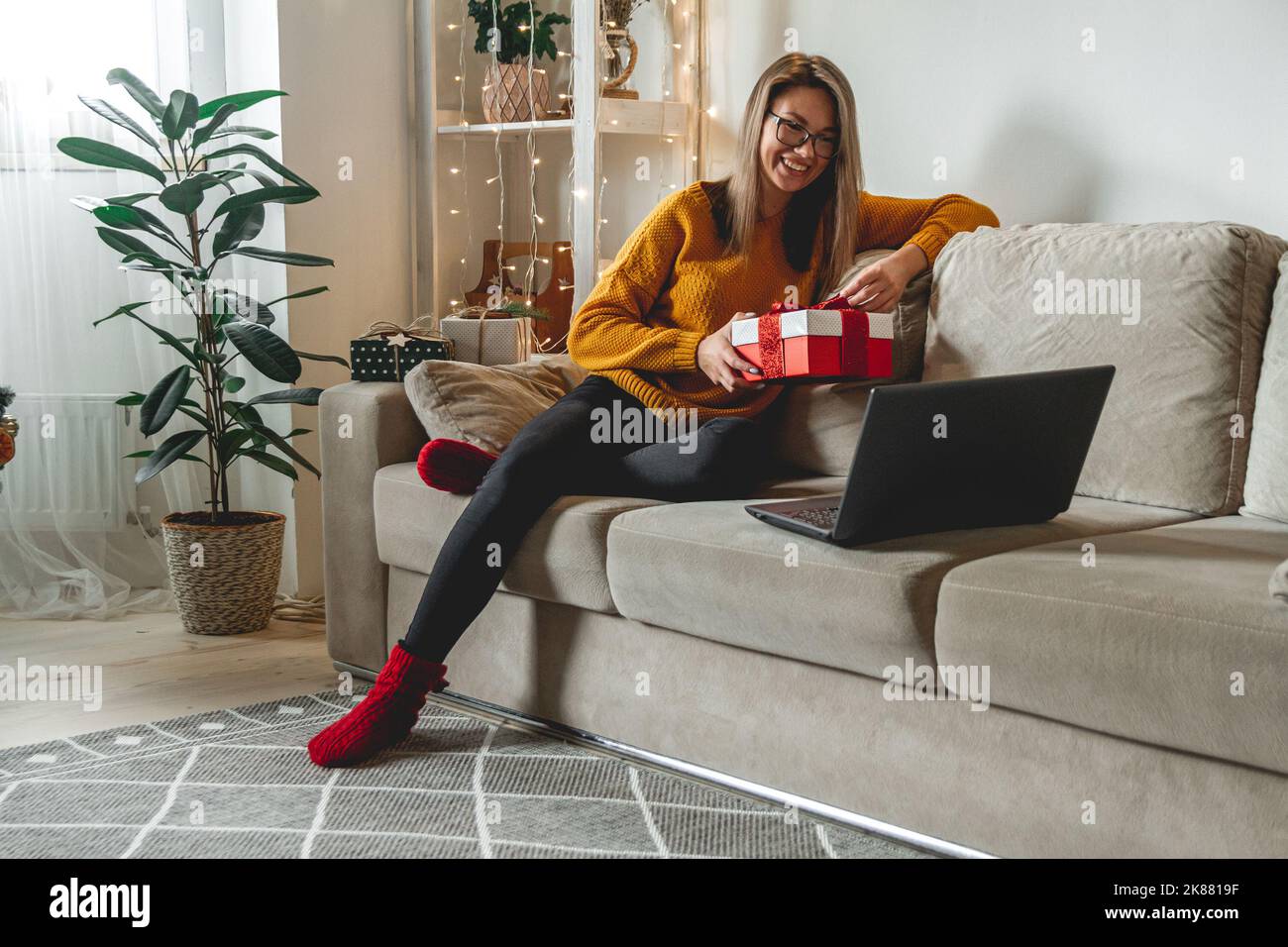 Young woman with laptop accepts online congratulations merry c Stock Photo