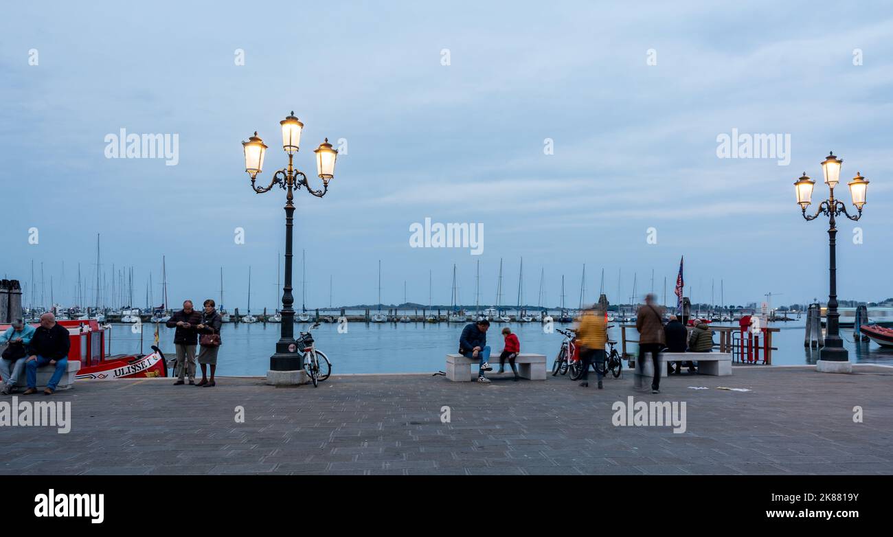 Tourists and locals relaxing and working on the Harbour waterfront -Chioggia Venetian Lagoon, Veneto regione, Italy, Europe Stock Photo