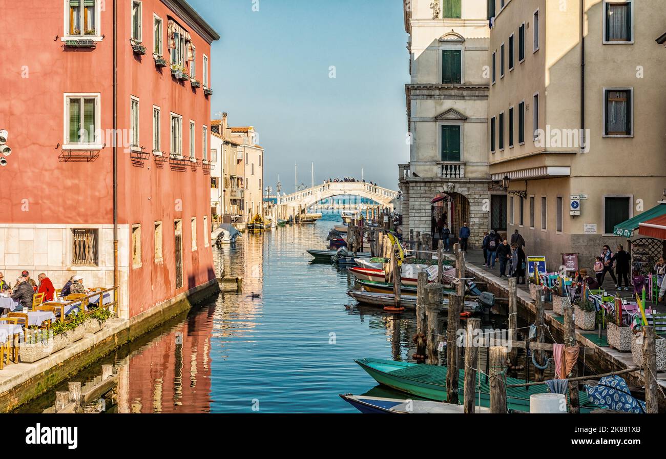 Cityscape of Chioggia with narrow water canal with moored boats, buildings - Venetian lagoon, Venice province, northern Italy - Europe Stock Photo