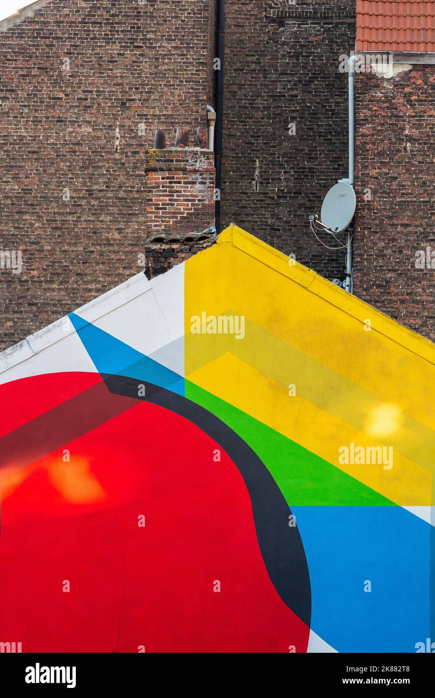 Brightly painted building gable. Dark brick walls in the background. Brussels. Stock Photo