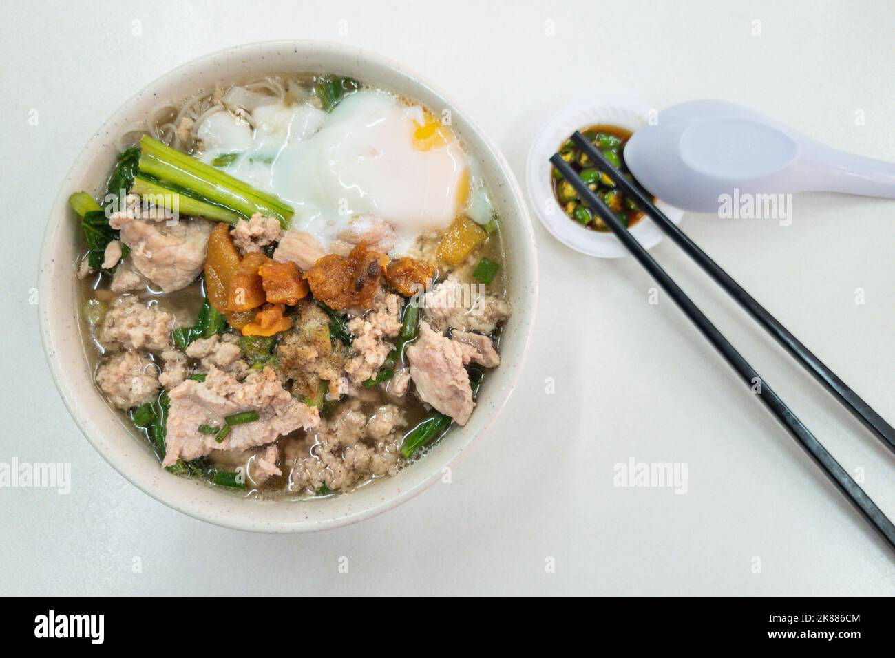 Overhead view of simple Chinese pork noodle soup with eggs served with
