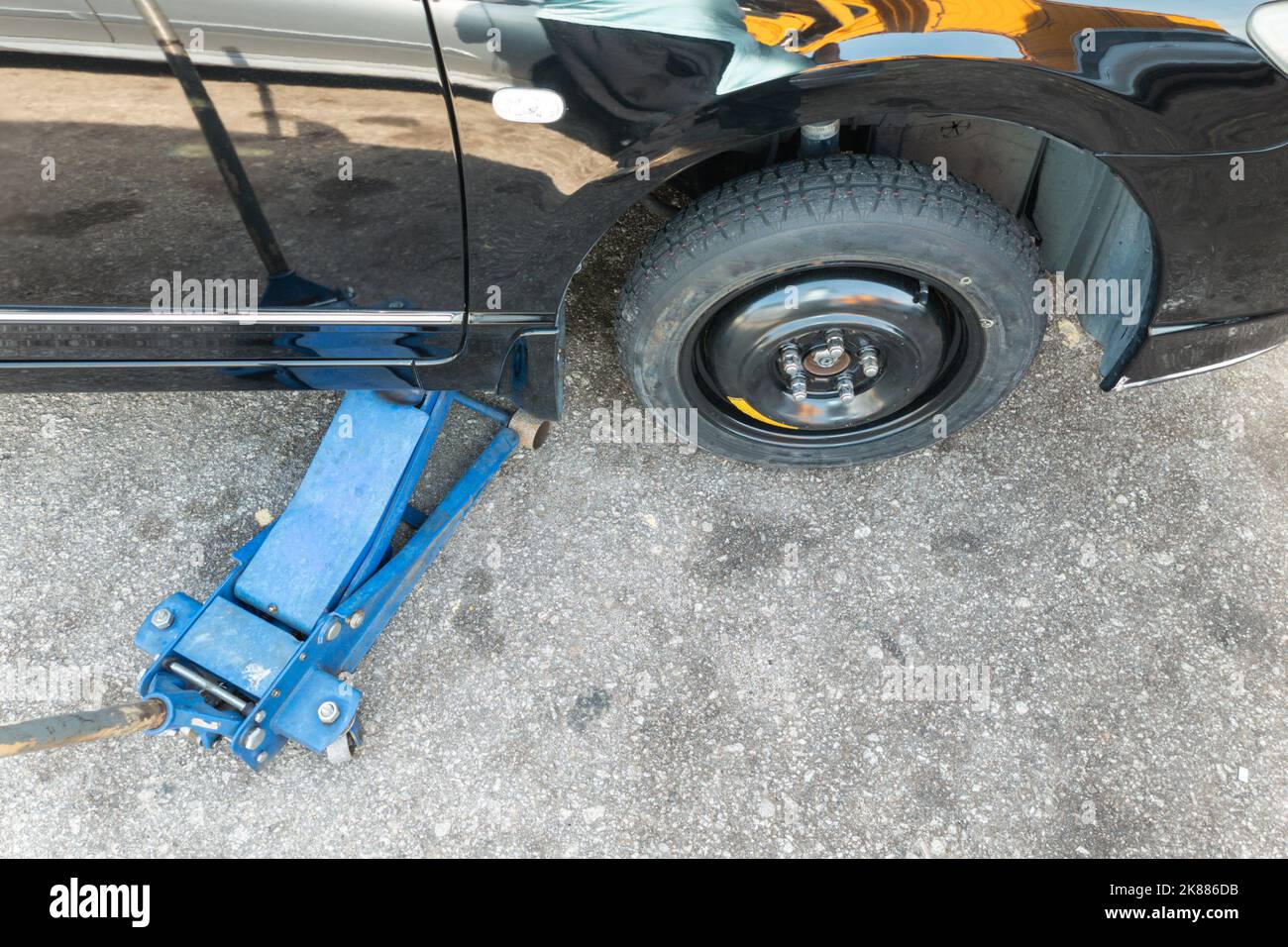 Hydraulic car jack lift car to replace punctured tyre with temporary