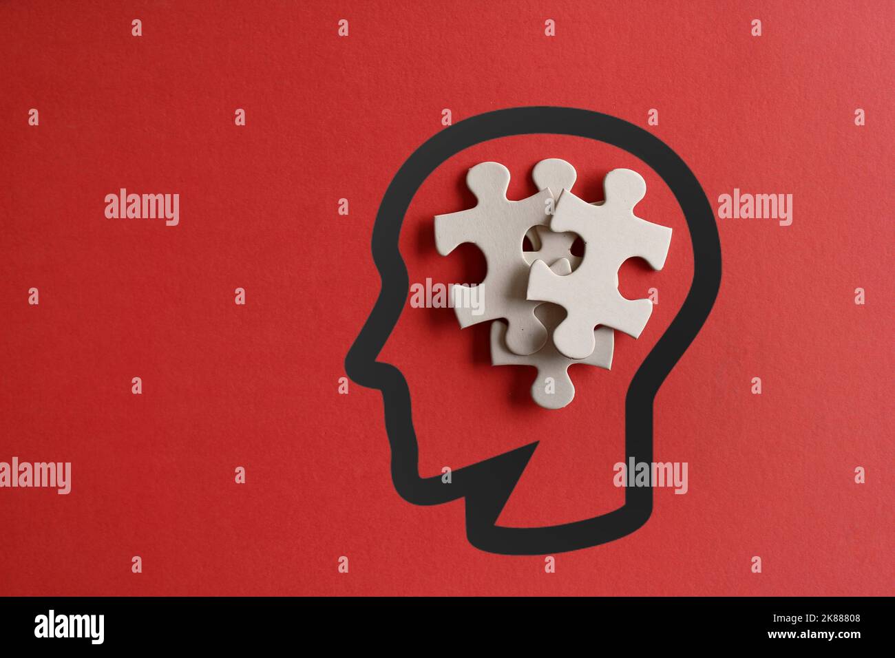 Scattered puzzles in human head with copy space on red background. Autism, down syndrome, stress and thinking concept Stock Photo