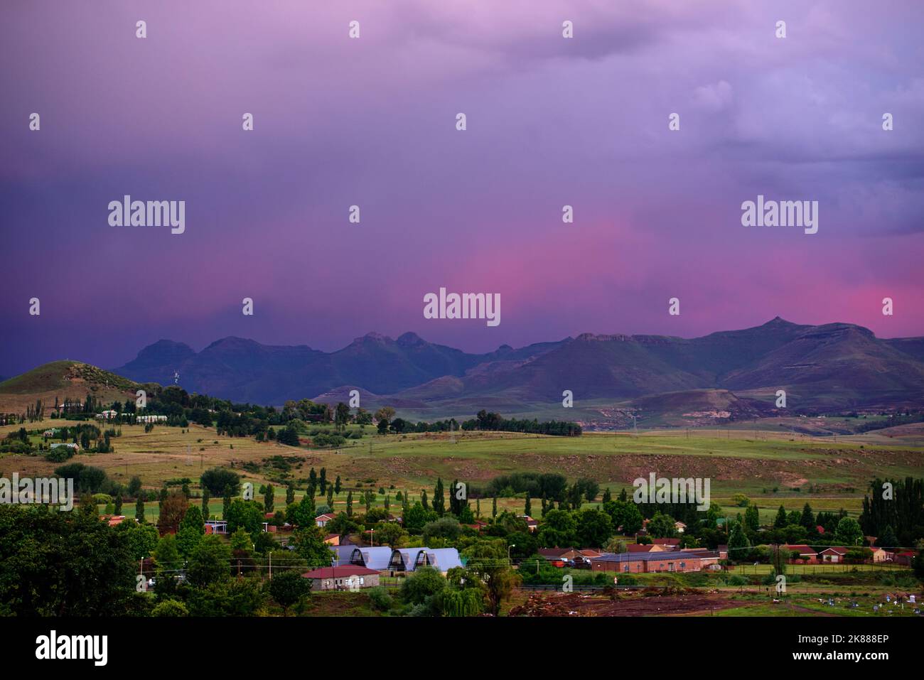 A view of the mountains under a stormy purple sky at sunset in Clarens, South Africa. The popular town is near the Golden Gate Highlands National Park Stock Photo