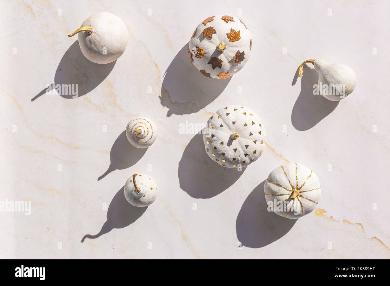 Pumpkins painted In white and gold dark shadows Stock Photo