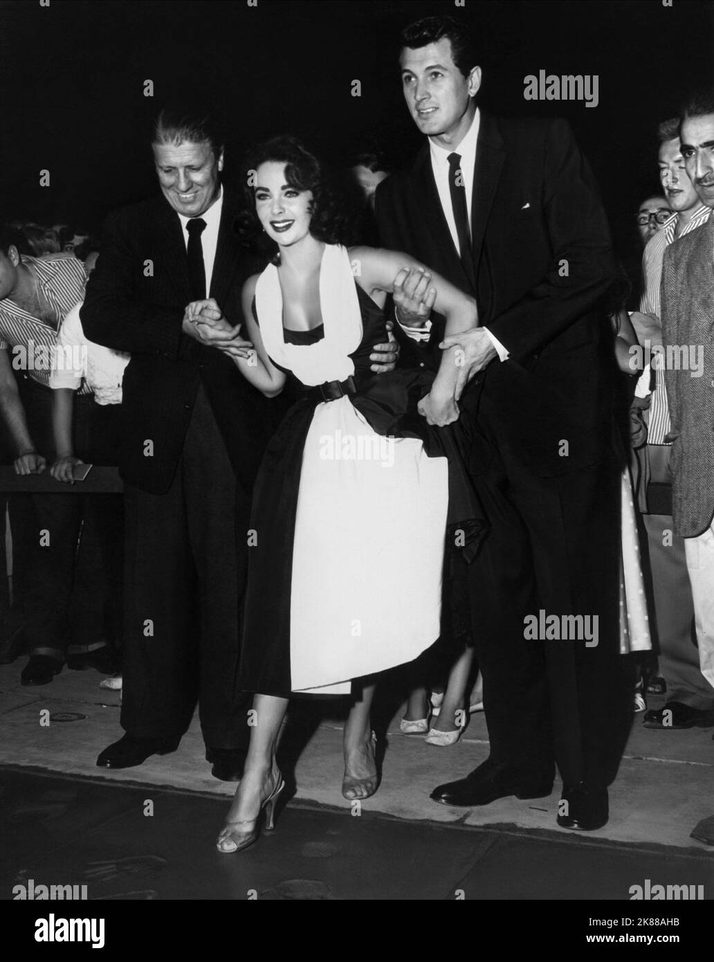 George Stevens, Elizabeth Taylor & Rock Hudson  Director, Actress & Actor (USA 1956)  / Bei Der Premiere Von 'Giganten'  10 October 1956   **WARNING** This Photograph is for editorial use only and is the copyright of The Film Company and/or the Photographer assigned by the Film or Production Company and can only be reproduced by publications in conjunction with the promotion of the above Film. A Mandatory Credit To The Film Company is required. The Photographer should also be credited when known. No commercial use can be granted without written authority from the Film Company. Stock Photo