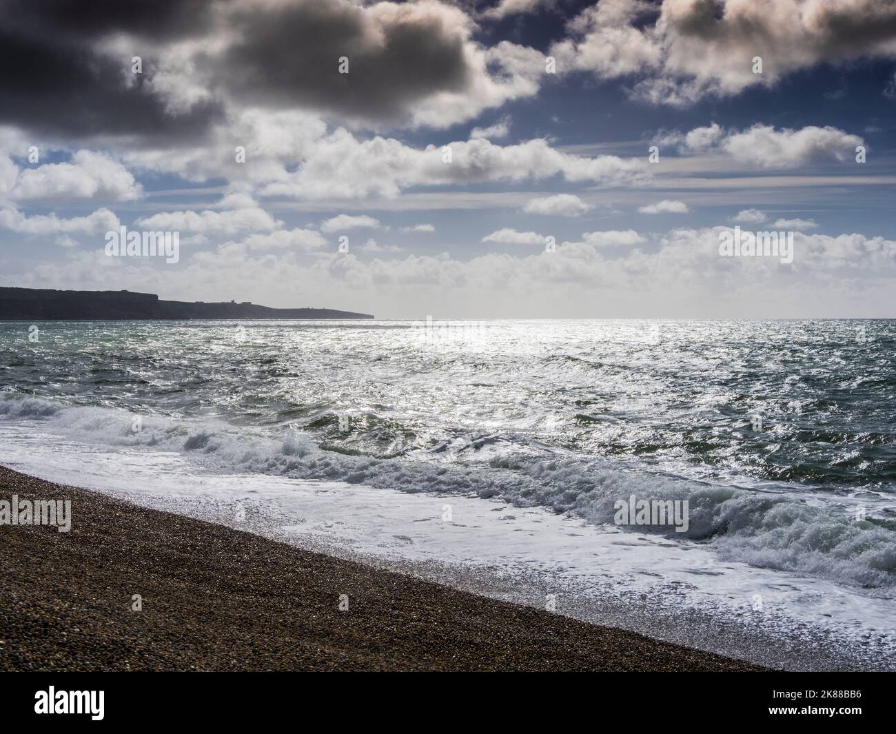 A contre jour image of storm clouds over Chesil Beach in Dorset. Stock Photo