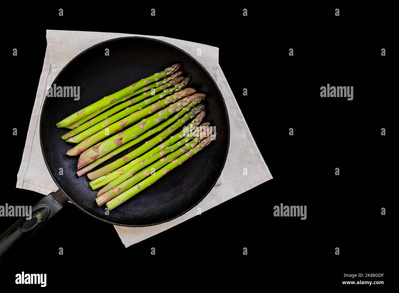 raw asparagus in a pan, black background, copy space Stock Photo