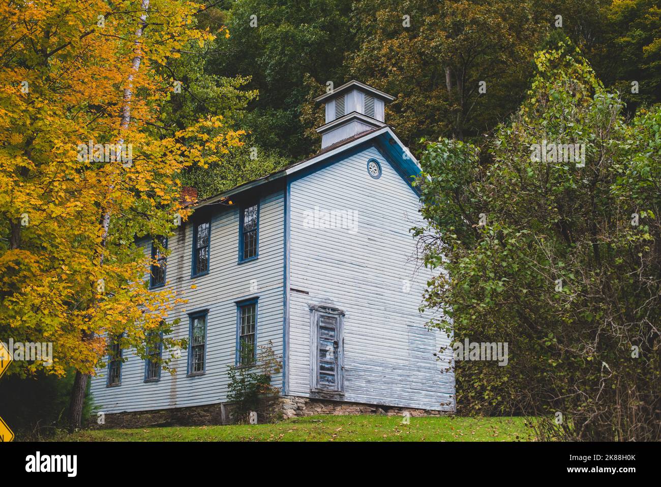 Old schoolhouse in rural Pennsylvania with fall foliage. - Stock Image