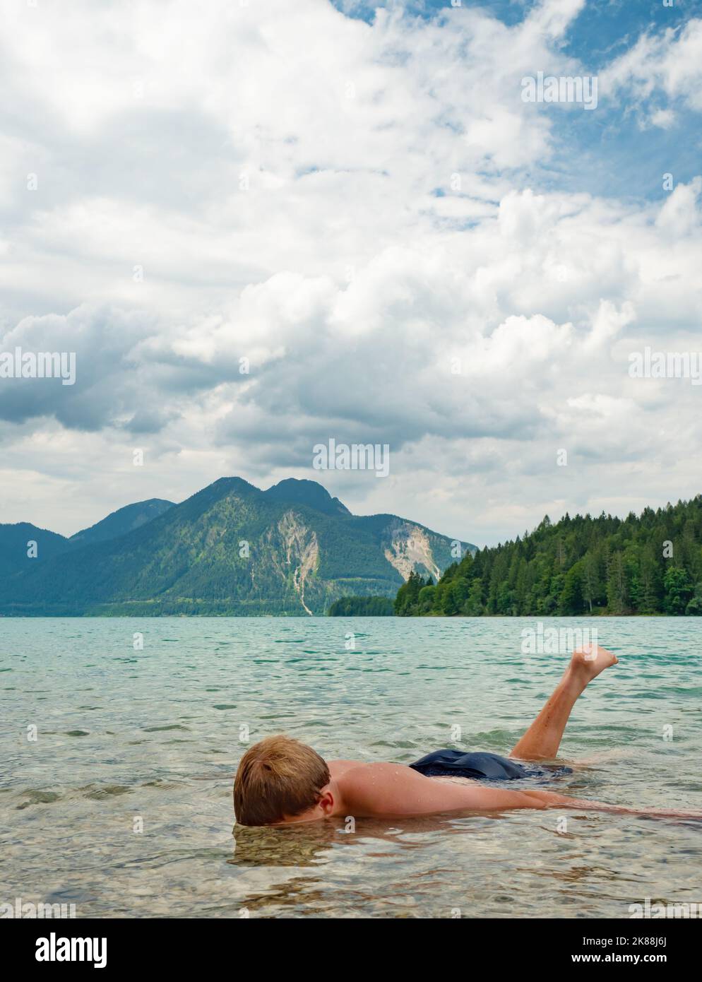 young-blond-hair-boy-is-swimming-in-mountain-lake-walchensee-nature