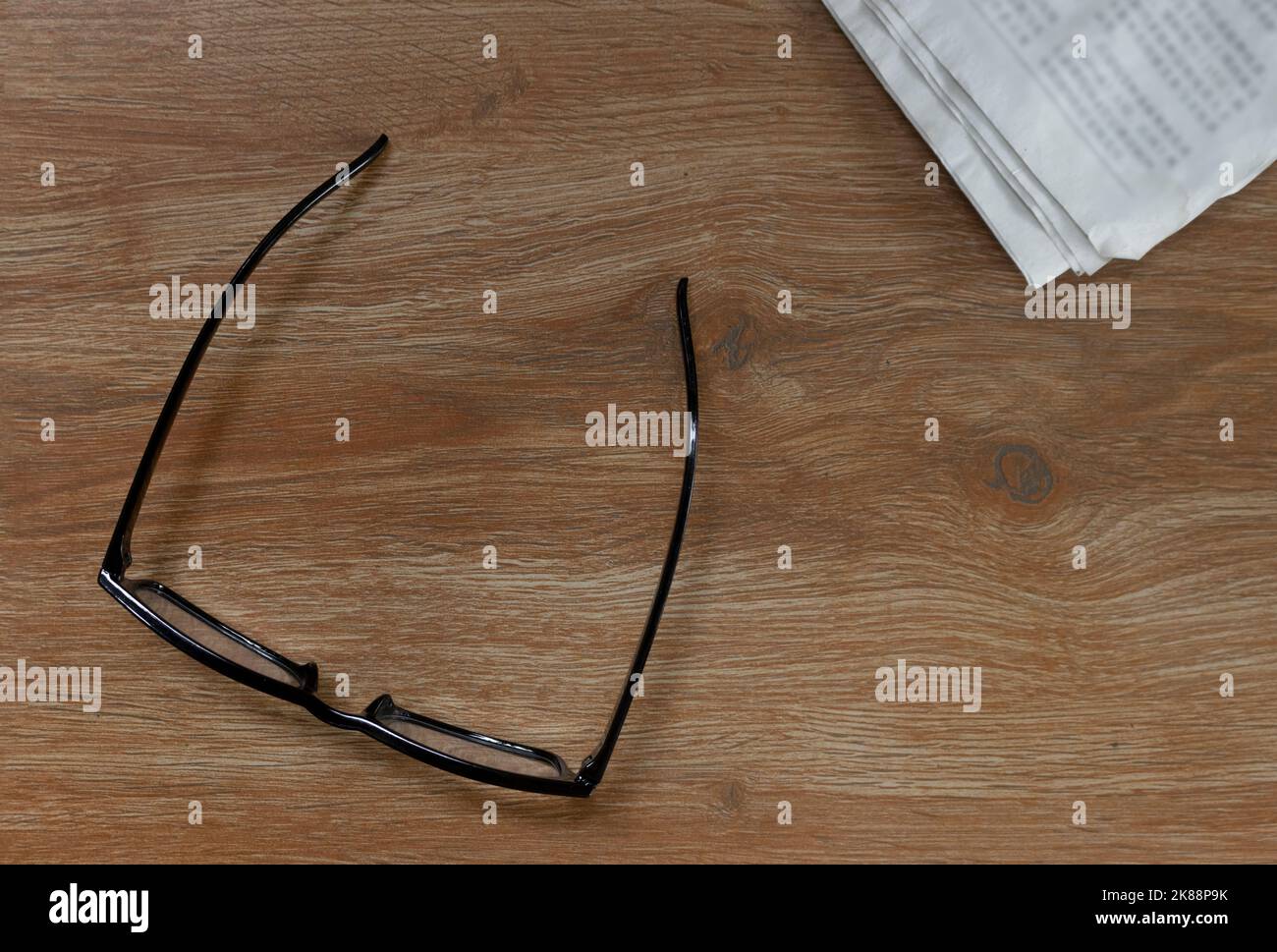 Reading glasses as a symbol of the aging human body. The concept of visual impairment - myopia and farsightedness. Close-up. Isolated on a brown. Stock Photo