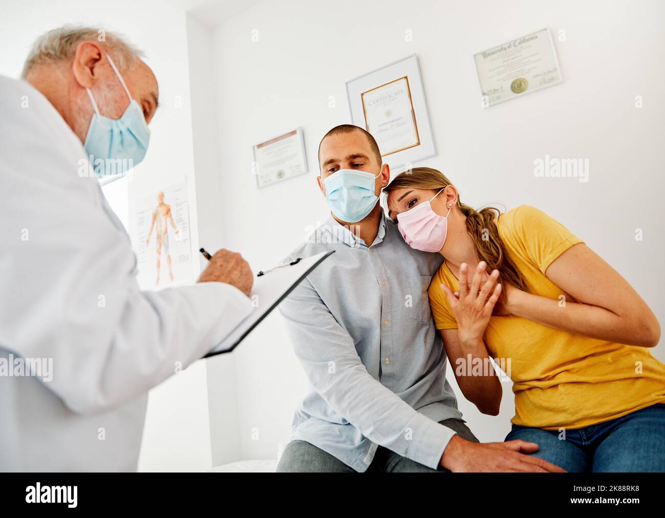 doctor patient woman man couple medical health care family chest pain mask virus medicine problem corona pregnancy Stock Photo
