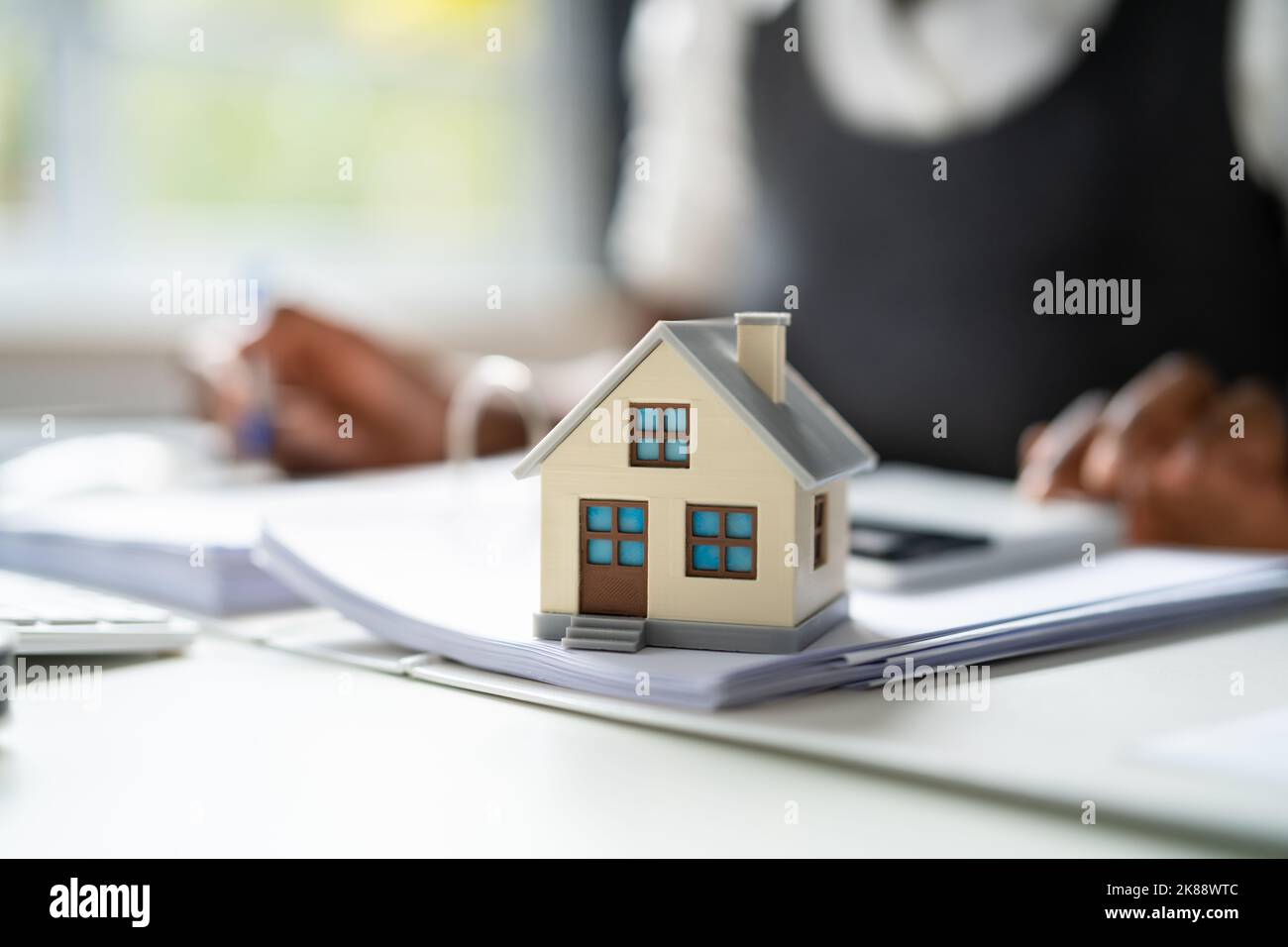 Person Hand Doing Property Tax Calculation Using Calculator Of House