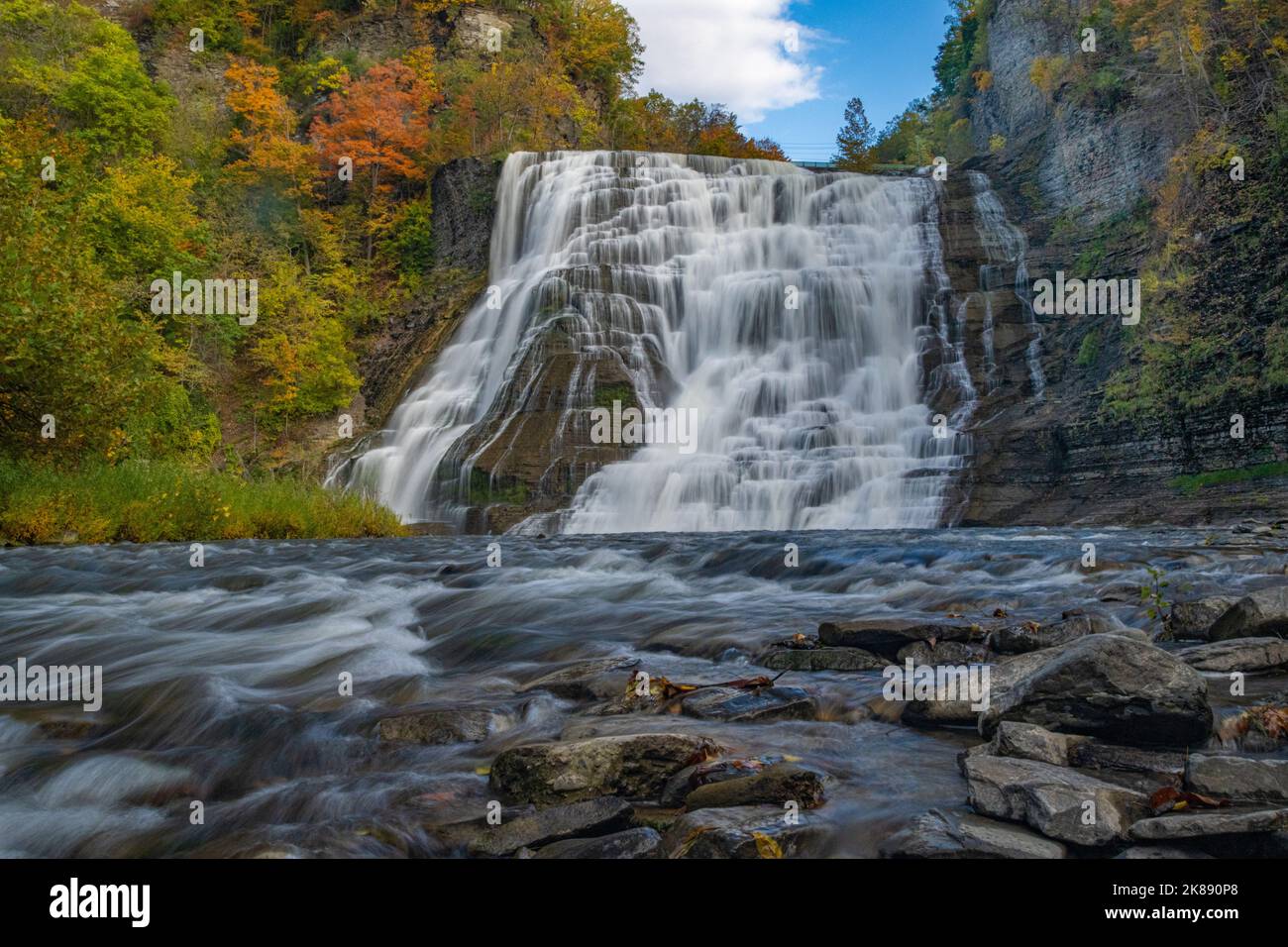 Ithaca Falls New York State with autumn trees / foliage turning color. Fall leaves andcolors w/ waterfall & long exposure blur - Finger Lakes region Stock Photo