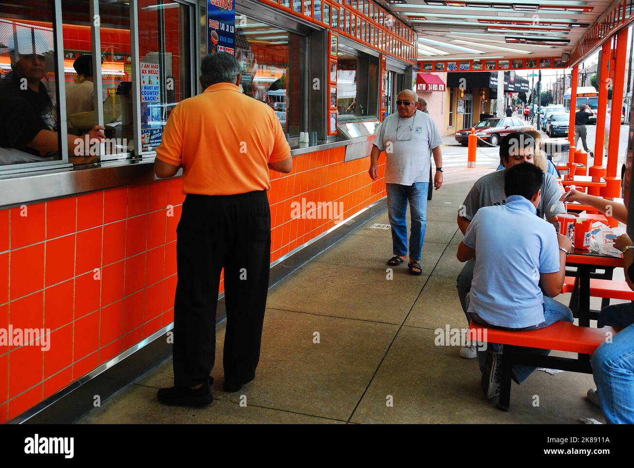 Customers enjoy a local South Philadelphia cheesesteak sandwich at Genos Steak, one of two rivals in South Philly Stock Photo