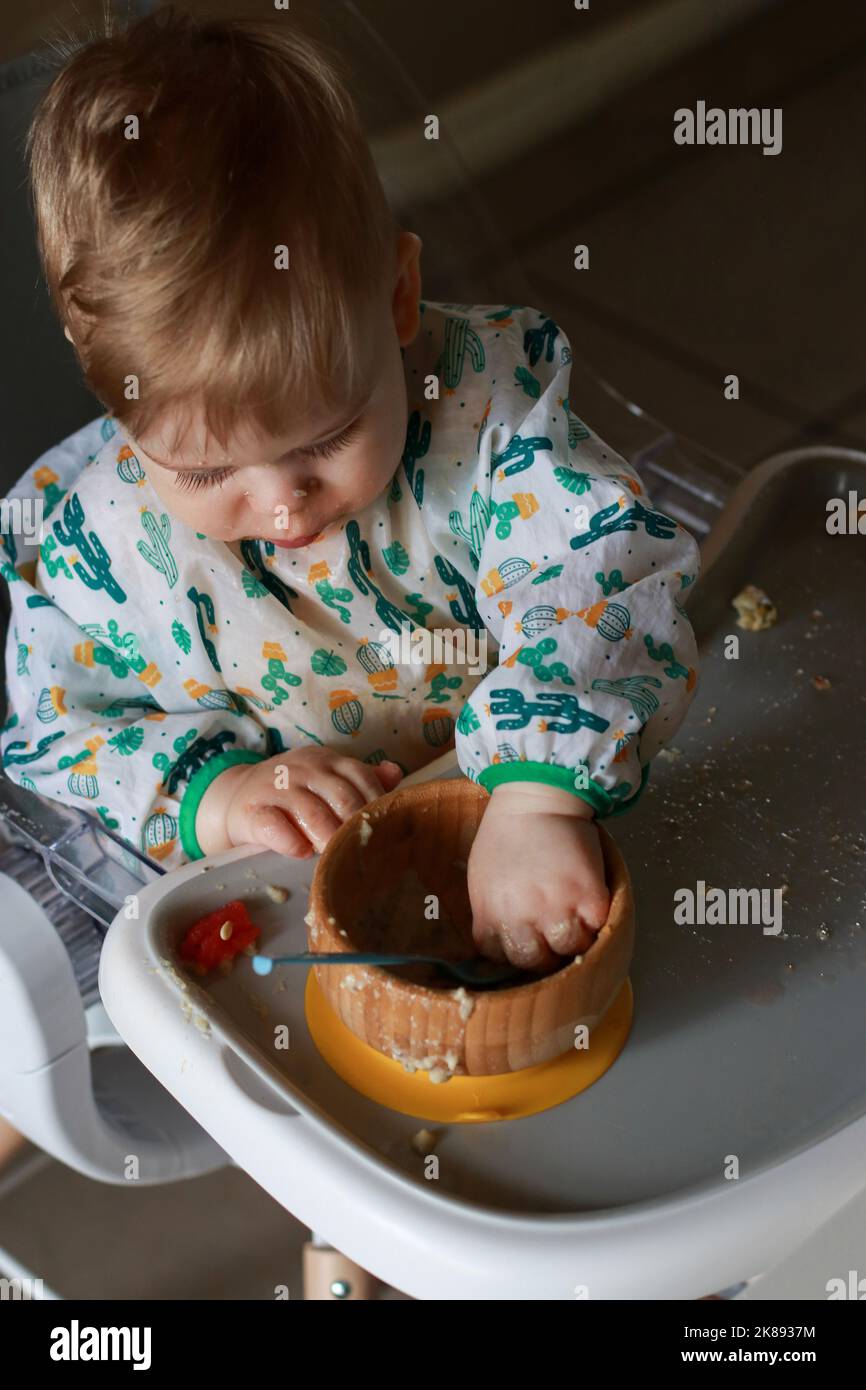 baby eating by himself learning through the Baby-led Weaning method Stock Photo