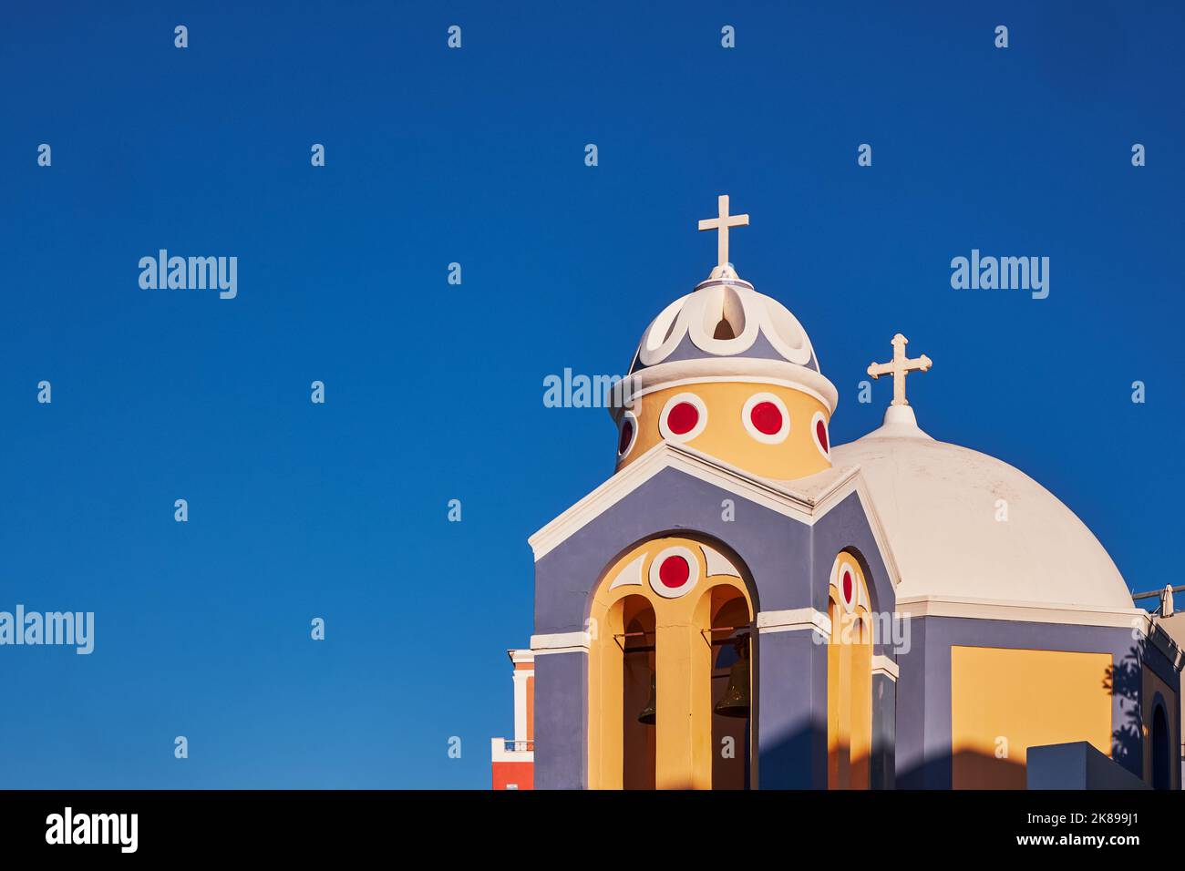 Catholic Church of Saint Stylianos against a Beautiful Blue Sky in Santorini Island, Greece - Domes, Colorful Stock Photo