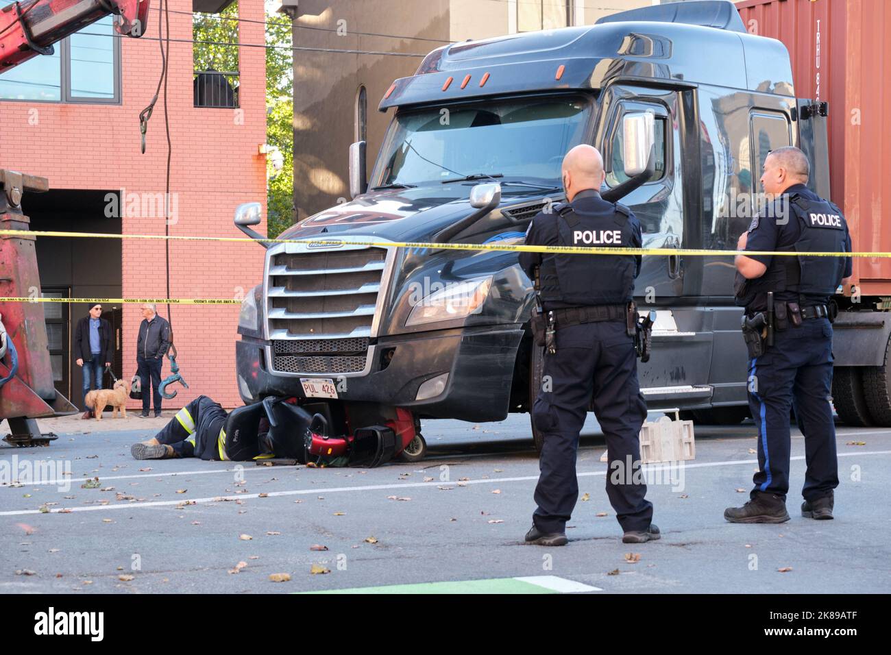 police at scene of Crushed mobility scooter under the front of large transport truck following accident in Halifax, Nova Scotia Stock Photo