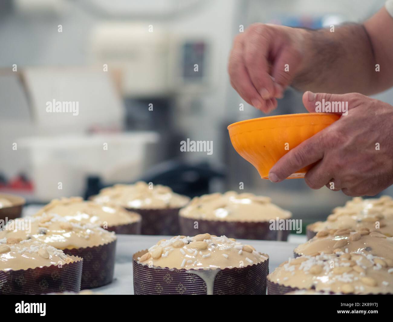 chef topping panettone italian cake with almonds Stock Photo