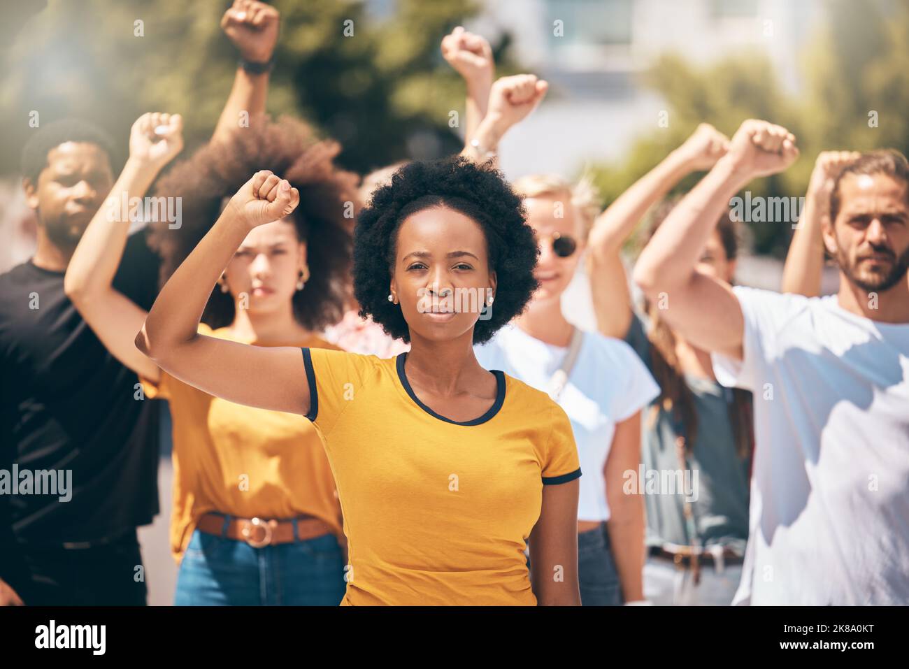 Protest, group of people with hands in air in street and solidarity for womans rights, human rights and against war. Diversity, men and women in crowd Stock Photo