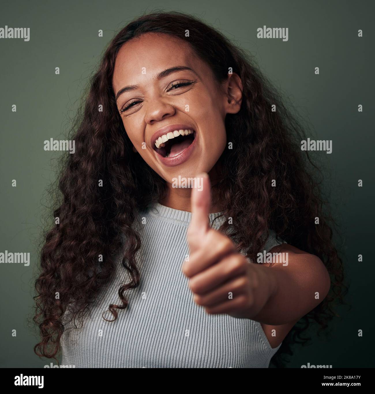 Love it Show me more. Studio shot of a young woman showing thumbs up ...
