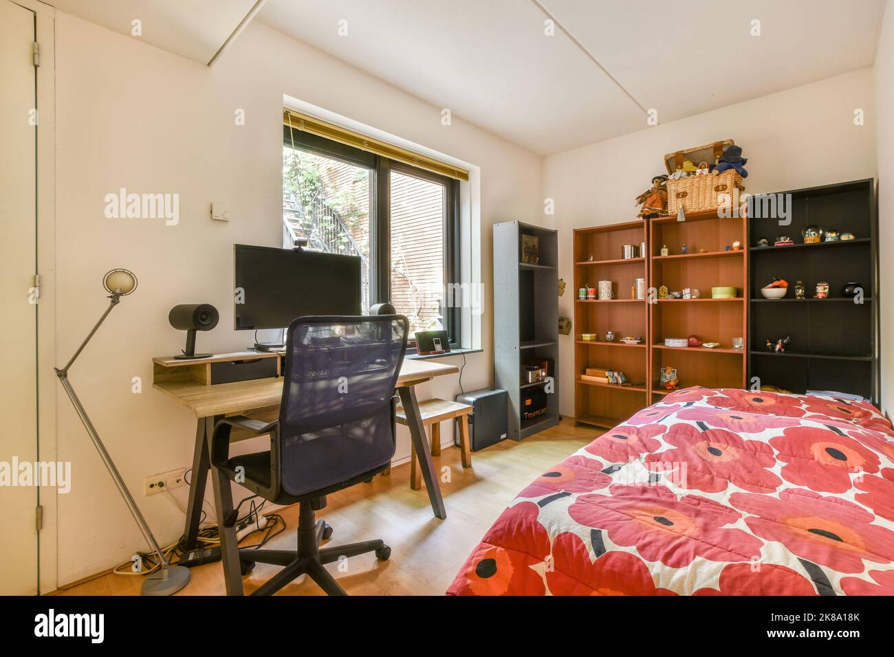 Comfortable chair placed near desk with computer monitors and bed in ...