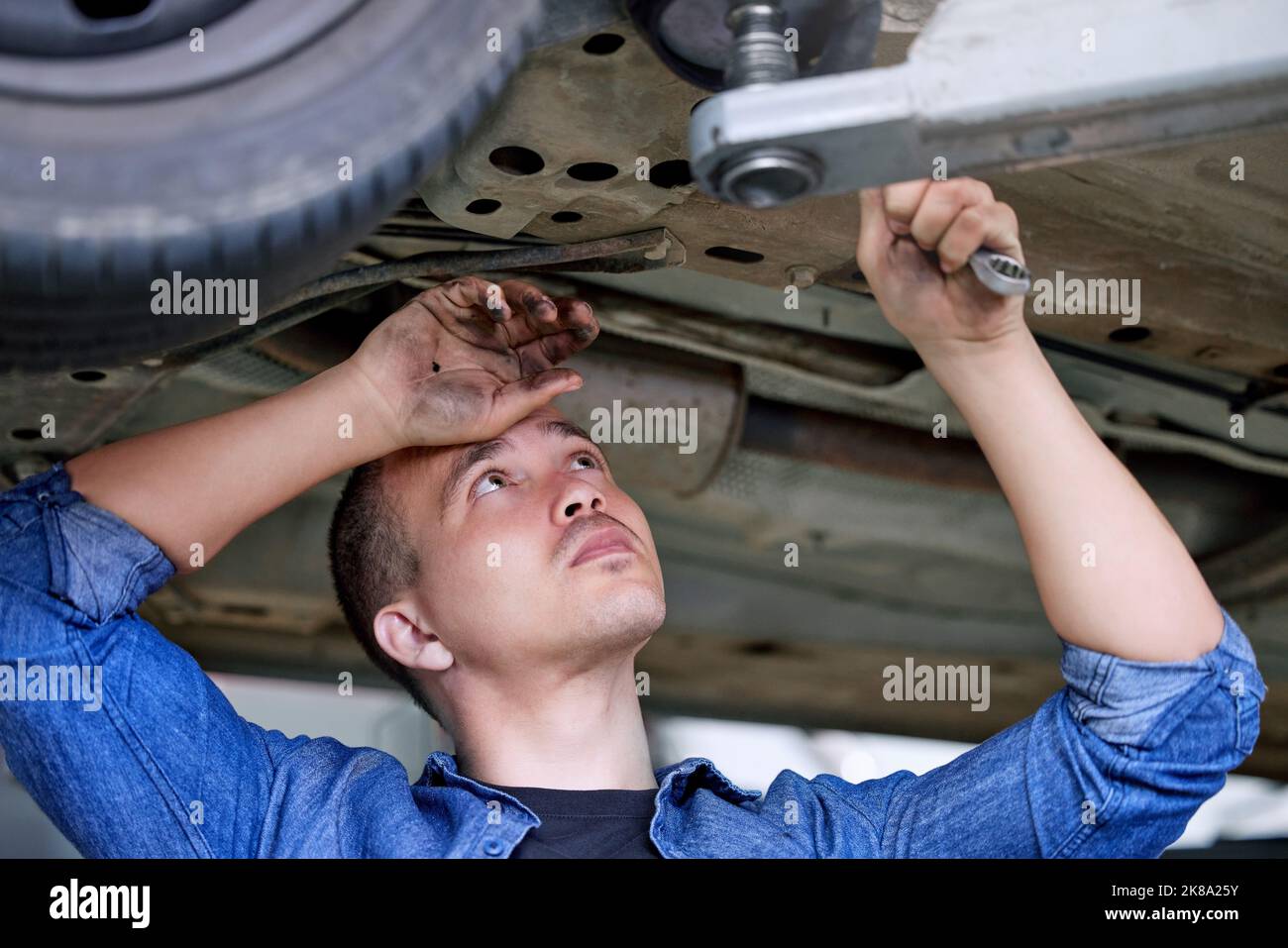 Car service, repair and mechanic working on car in the garage or