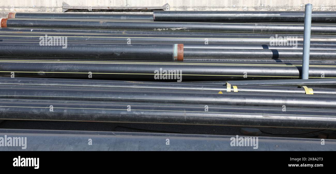 black plastic pipes in the deposit of building material on the road