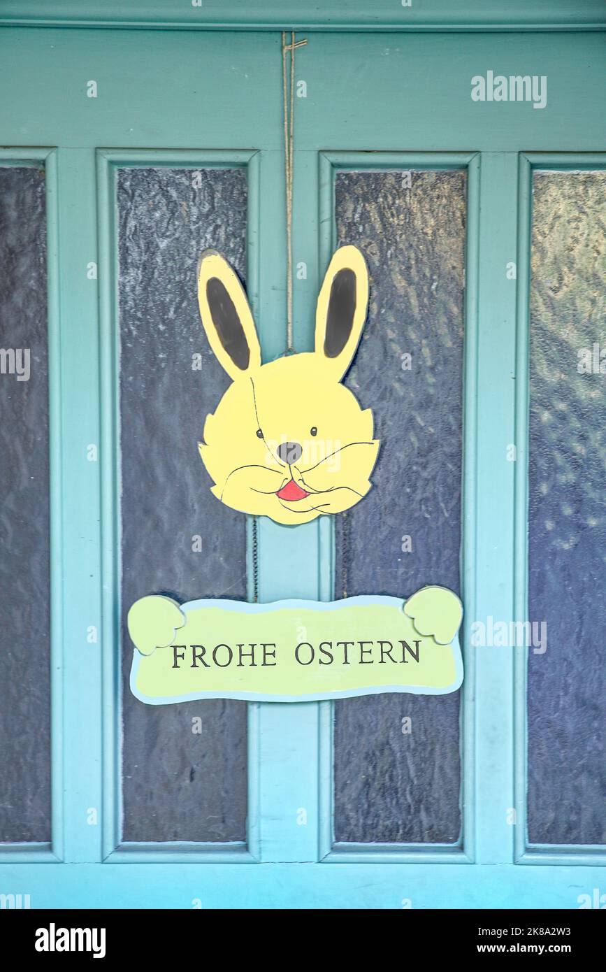 Hase mit Schild Frohe Ostern an Haustüre Stock Photo