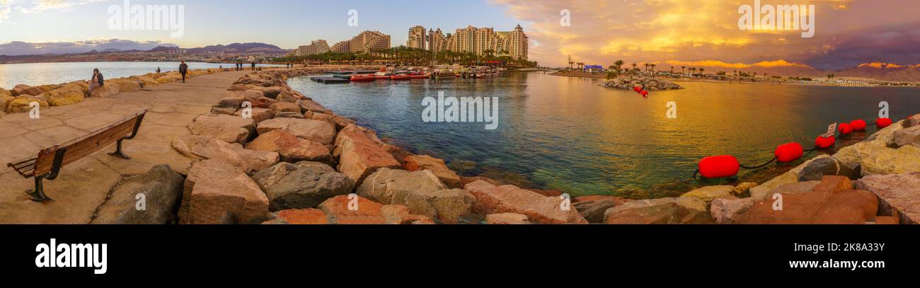 Eilat, Israel - January 15, 2022: Winter sunset panorama of the marina pier, with visitors and hotel buildings. Eilat, southern Israel Stock Photo