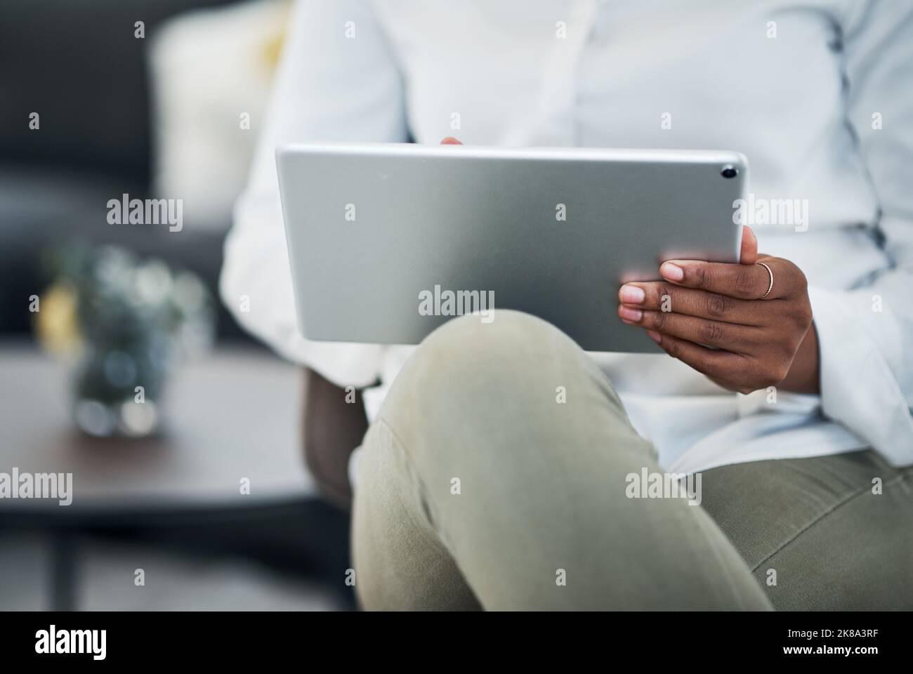 I carry my schedule everywhere. an unrecognizable businesswoman sitting alone and using a digital tablet to work from home. Stock Photo