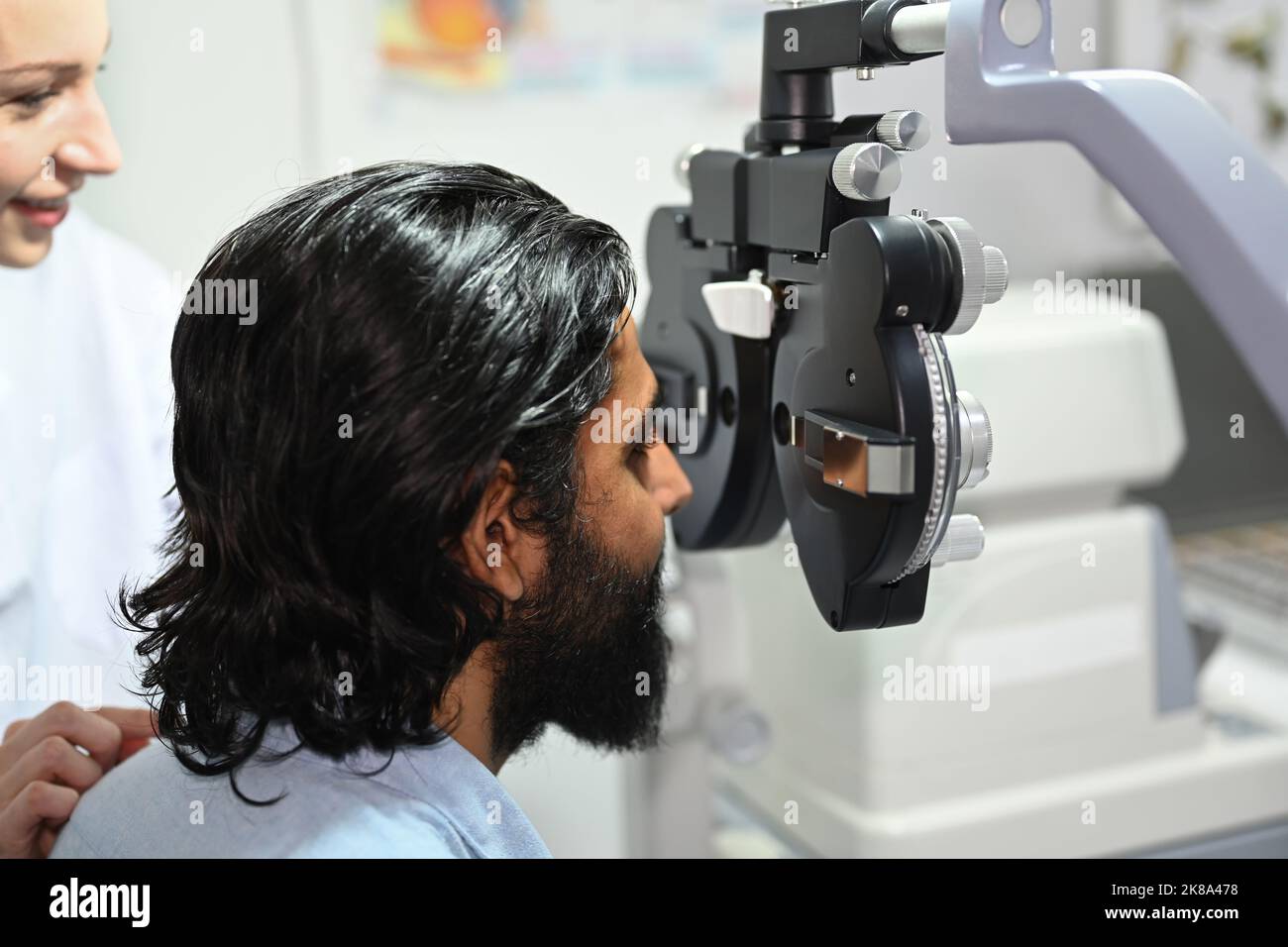 Side view of Indian man is checking the eye vision with phoropter