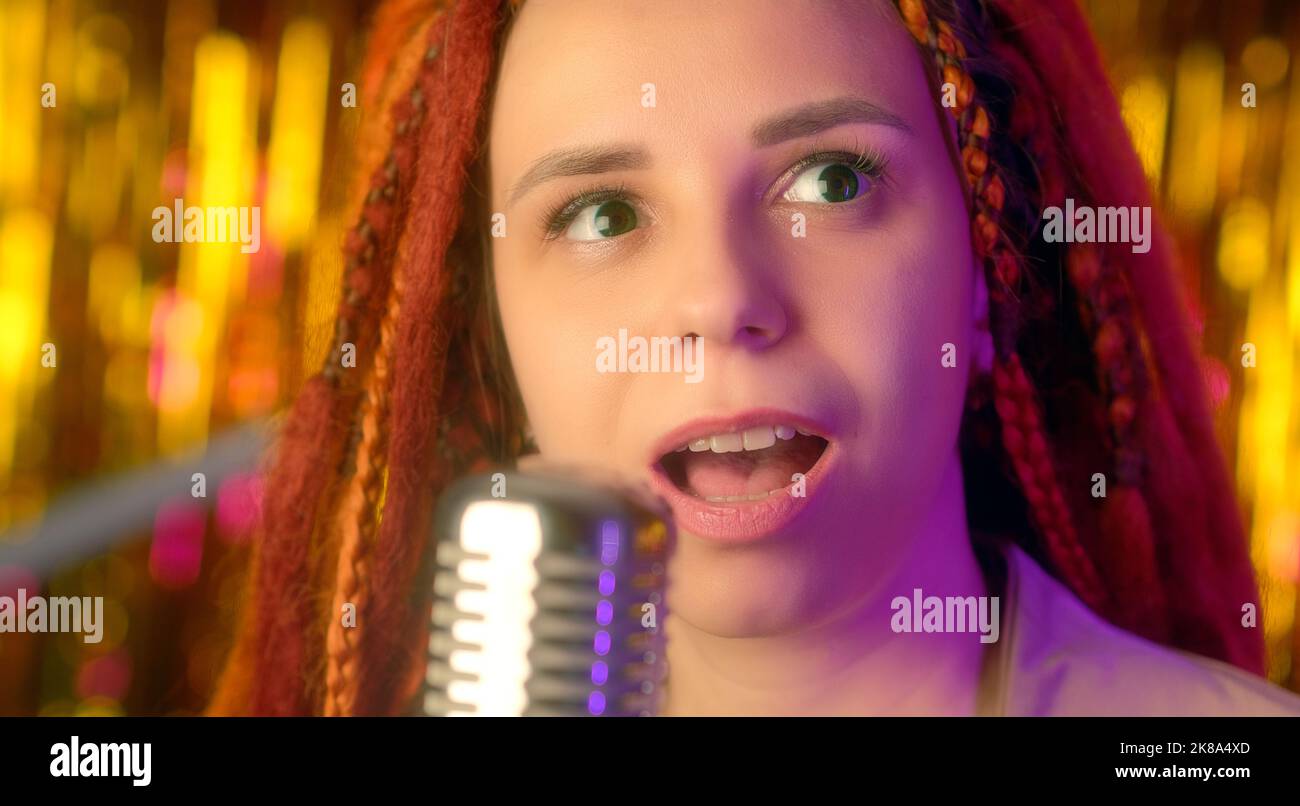 Young Woman With Ginger Dreadlocks Singing Into Microphone Portrait Of young-woman-with-ginger-dreadlocks-singing-into-microphone-portrait-of