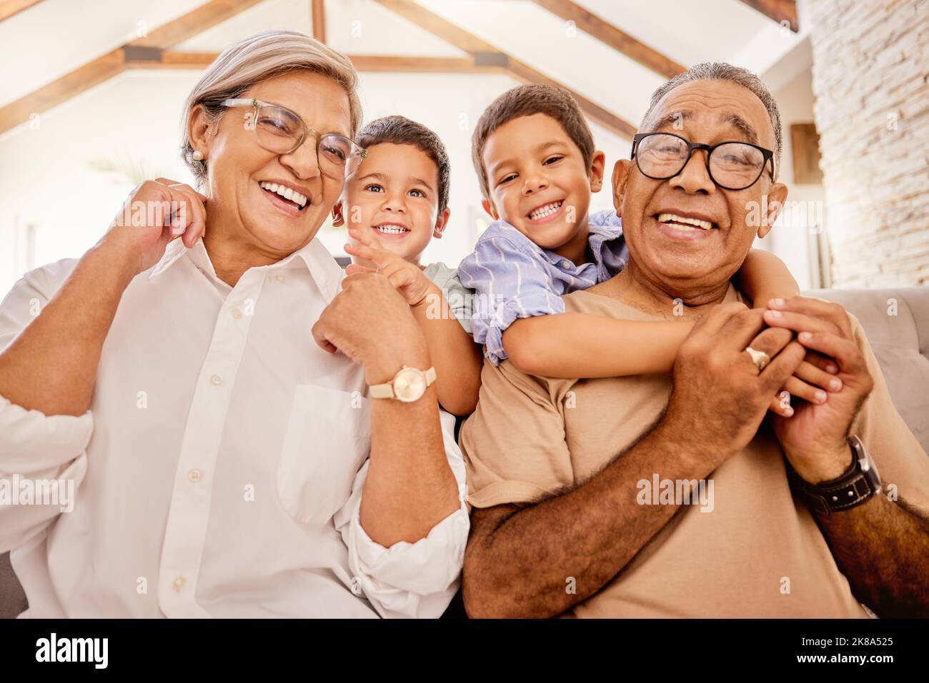 Grandparents, children and sofa happy in home living room on vacation or holiday together. Kids, grandma and grandpa in retirement smile on couch in Stock Photo