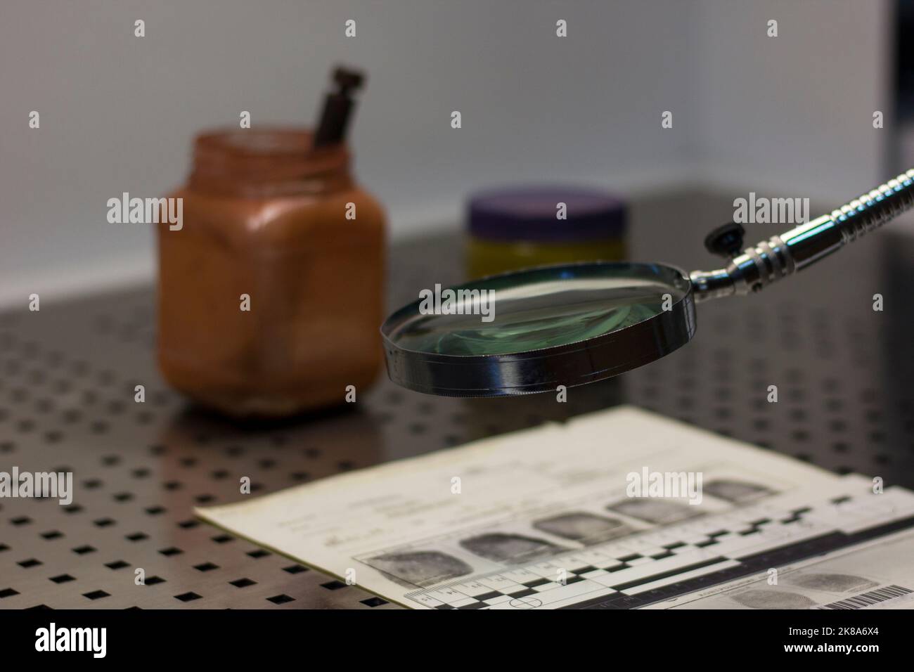 Forensic ruler, magnifying glass, fingerprint card and a jar of