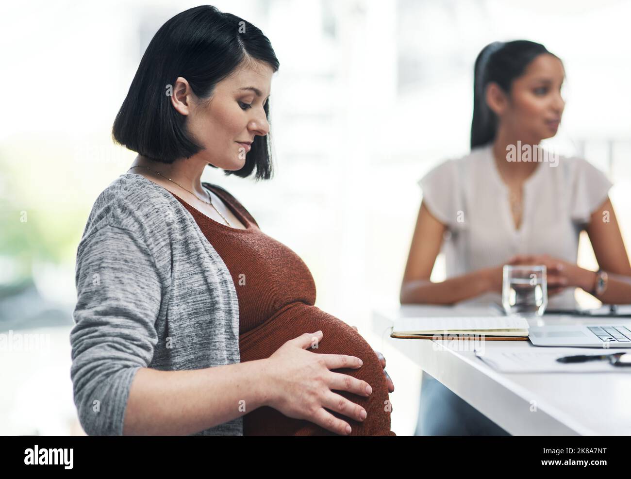 Is pregnancy distracting her from their project. a pregnant young businesswoman having a team