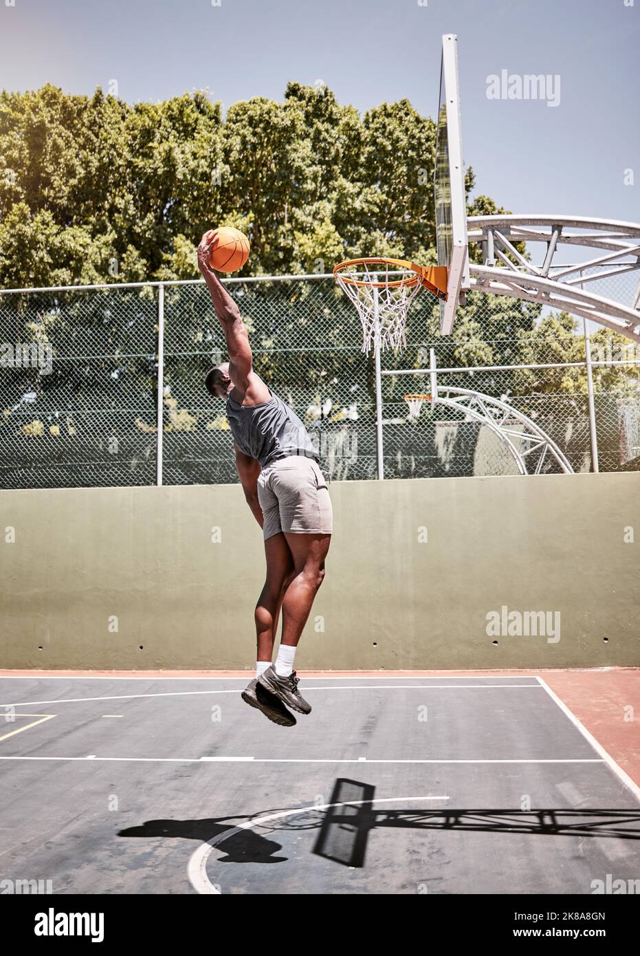Basketball dunk, sport and strong black man athlete on a outdoor basketball court with fitness. Sports person basketball player with cardio workout Stock Photo